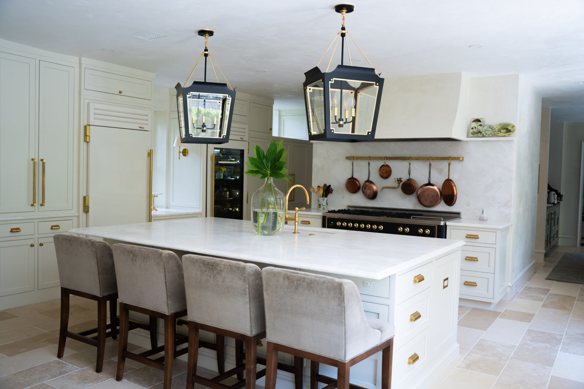A kitchen with white cabinets and gold fixtures.